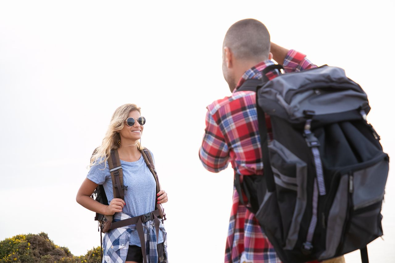 services-01 Happy couple hiking with backpacks in sunny Portugal. Enjoying outdoor adventure together.